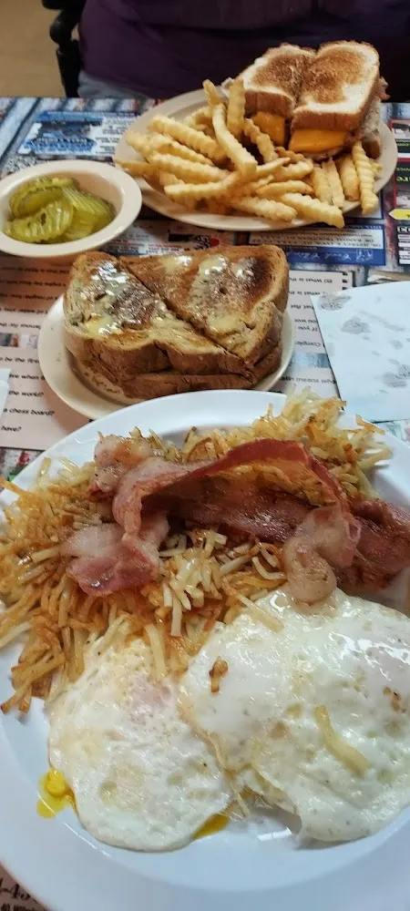 Three Eggs over Medium Soft Bacon Crispy Hash Browns and Buttered Rye Toast